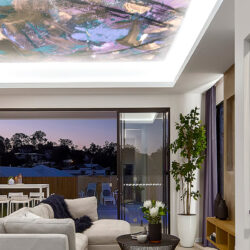 picture of an abstract art ceiling mural in a stately lmodern living room overlooking a canal at sunset